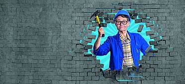 Handwerker Peters ragt aus Loch aus der Wand.