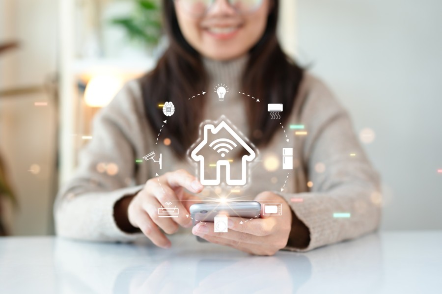 Frau steuert Smart-Home-Geräte per Smartphone, zentrale Hausautomation mit WLAN-Verbindung und intelligenten Funktionen.