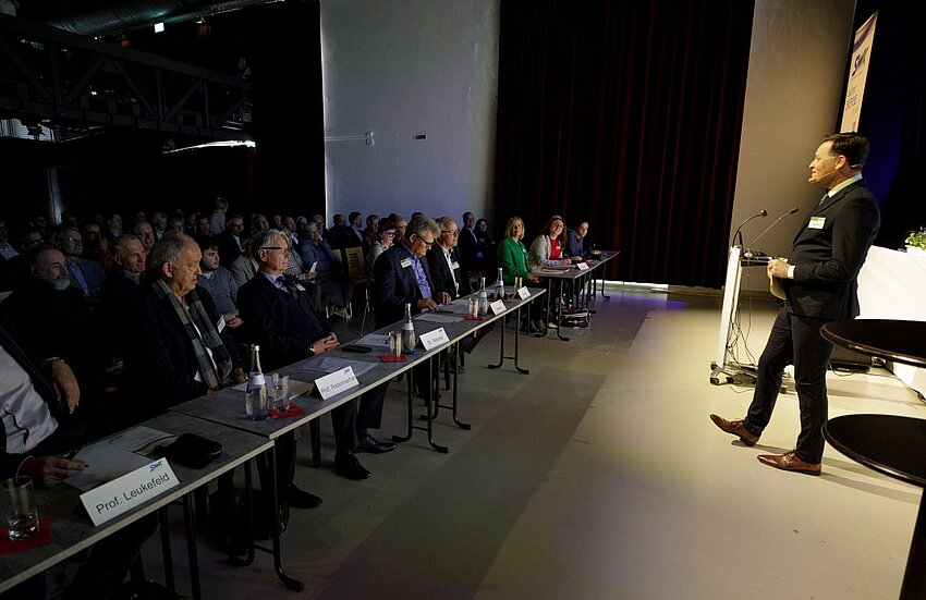 Mann spricht auf Bühne Energieforum vor Publikum
