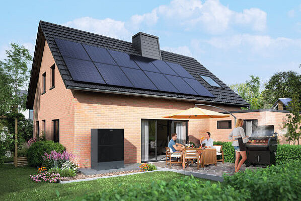Außenansicht eines Einfamilienhauses mit eingerichtetem Garten, Solardach und Wärmepumpe.