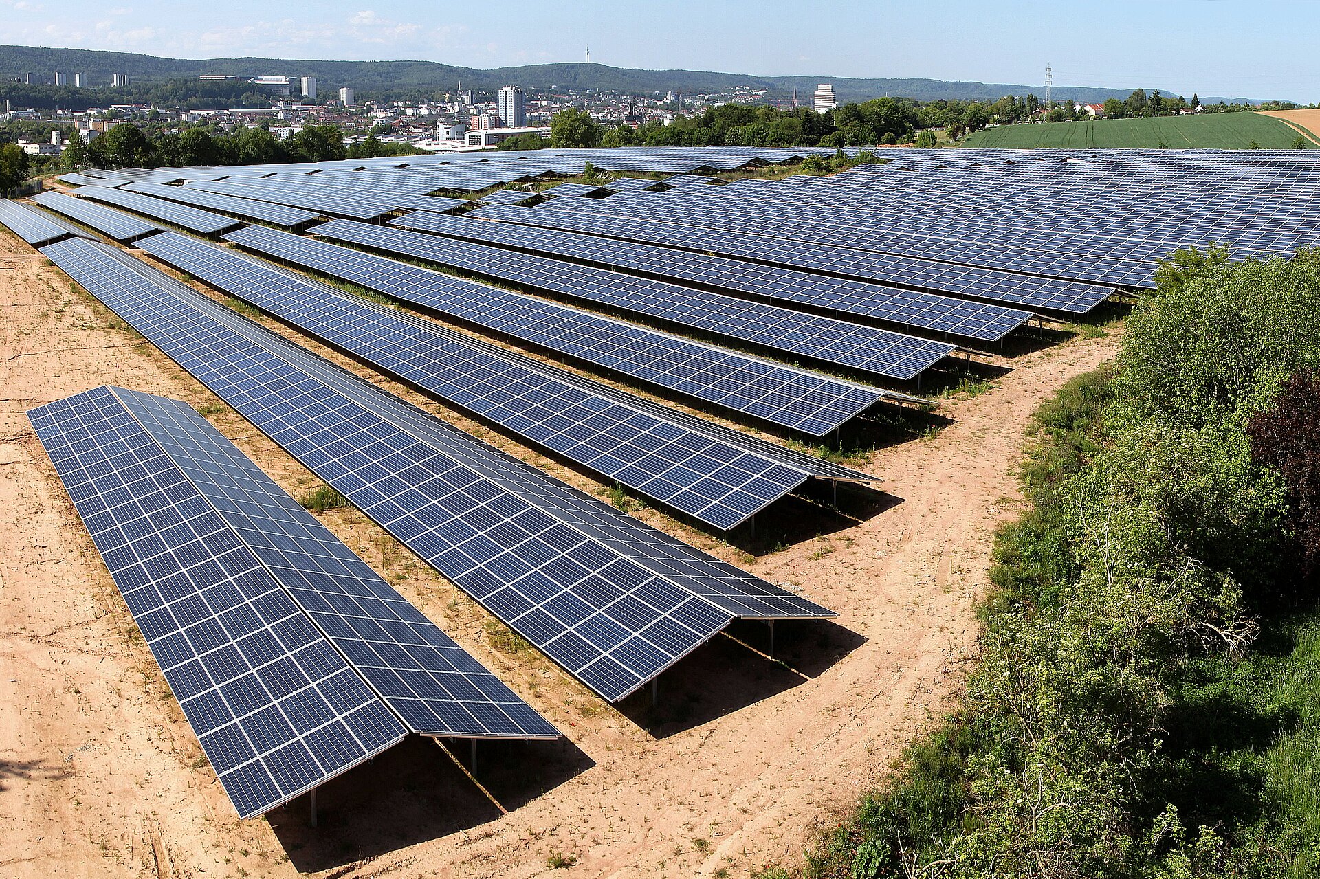 Luftaufnahme auf eine Photovoltaik-Anlage auf einer Fläche abseits der Stadt