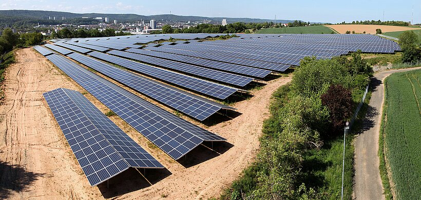 Luftaufnahme auf eine Photovoltaik-Anlage auf einer Fläche abseits der Stadt