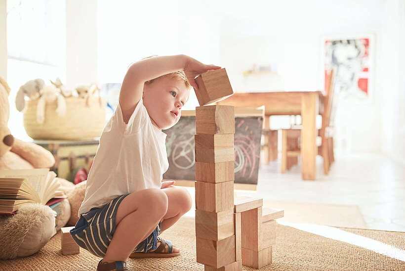 Kind spielt und baut mit Bausteinen