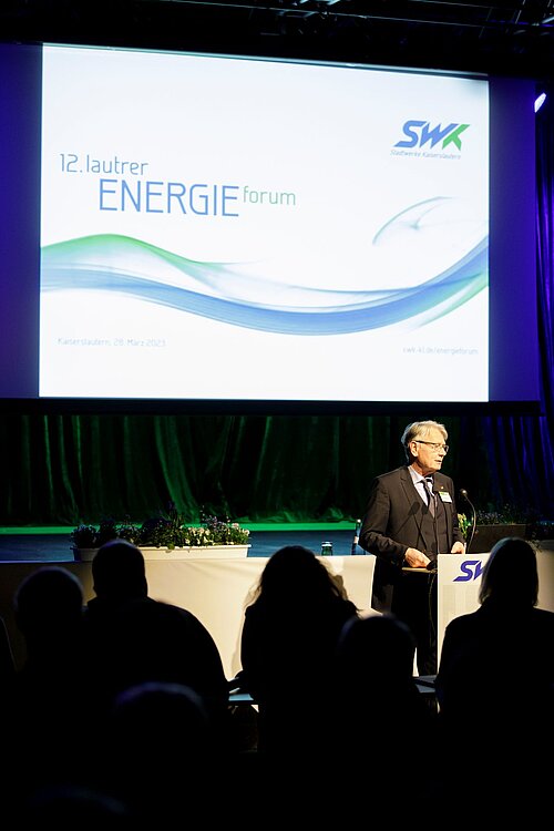 Mann spricht auf Bühne Energieforum vor Publikum