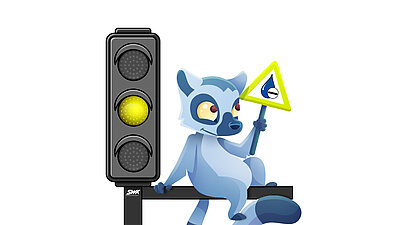 Comic-Lemur sitzt neben gelber Ampel und hält ein Warnschild hoch.