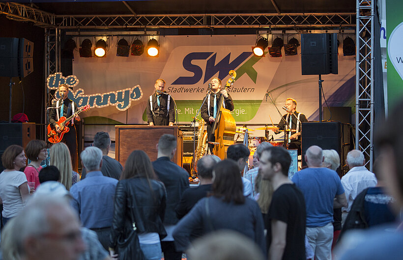 Menschenmenge vor Bühne mit Band und SWK-Banner im Hintergrund