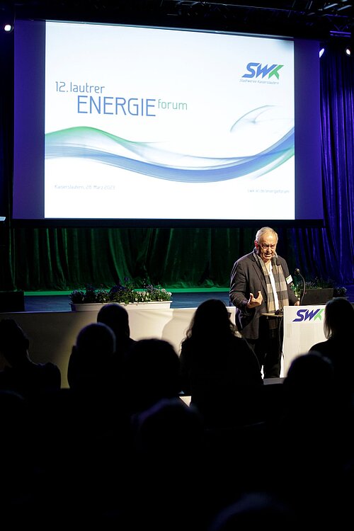 Mann spricht auf Bühne Energieforum vor Publikum