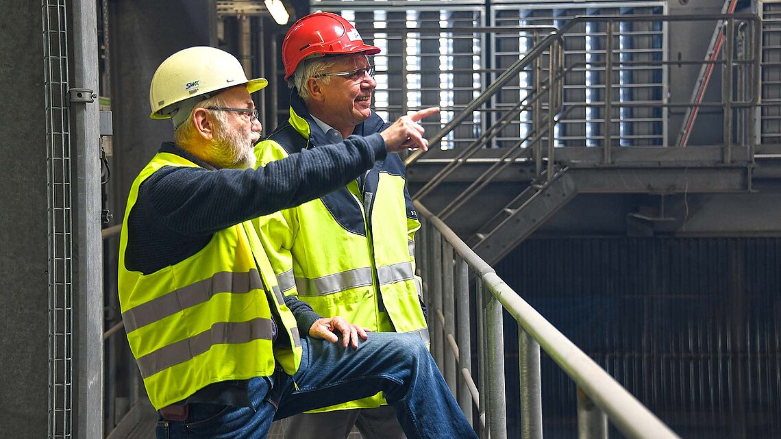Arbeiter mit Schutzhelm und Schutzweste im Heizkraftwerk Innenbereich 