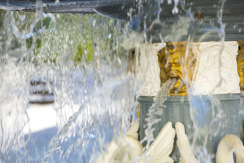 Martinsbrunnen mit fließendem Wasser und Goldverzierungen an Brunnen