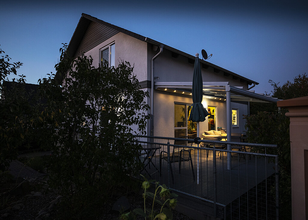 Wohnhaus mit Veranda Glasvordach und Tischen und Stühlen