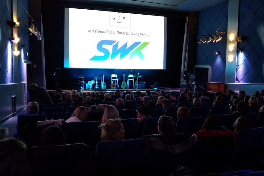 Kinossal mit Personen, auf Leinwand Werbung mit freundlicher Unterstützung SWK 