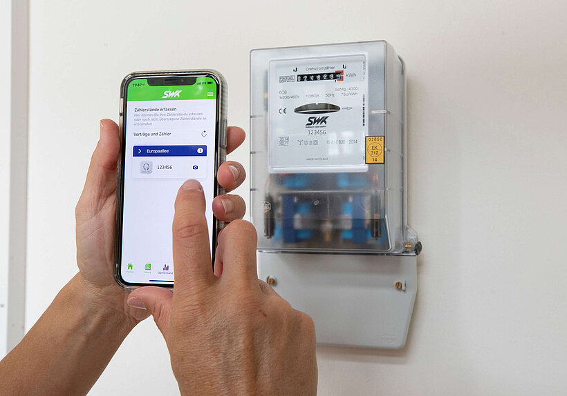 Person hält Handy in Hand mit SWK-App zum Zählerstände erfassen 