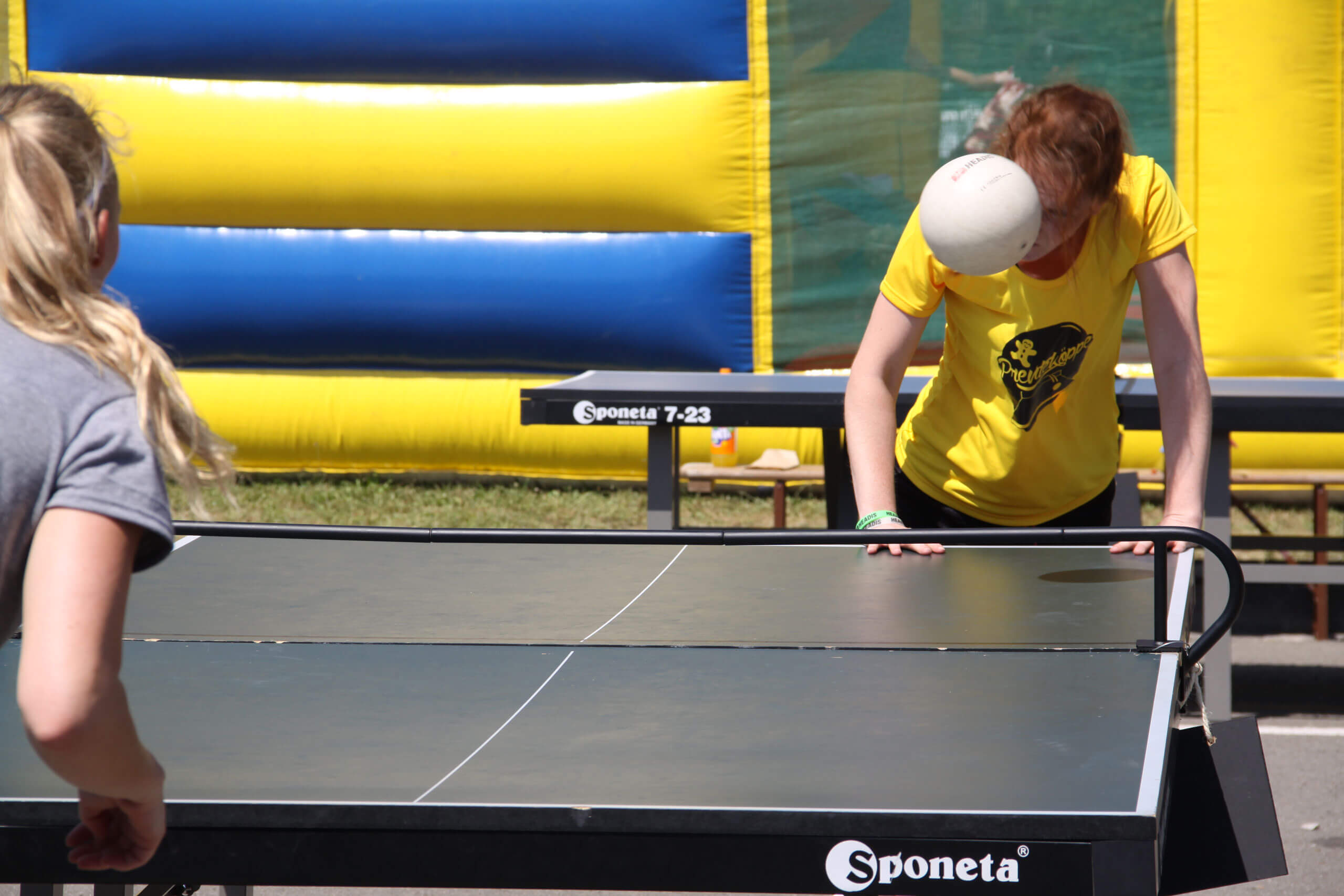 Frauen spielen Headis, Tischtennis mit einem Fußball mit dem Kopf