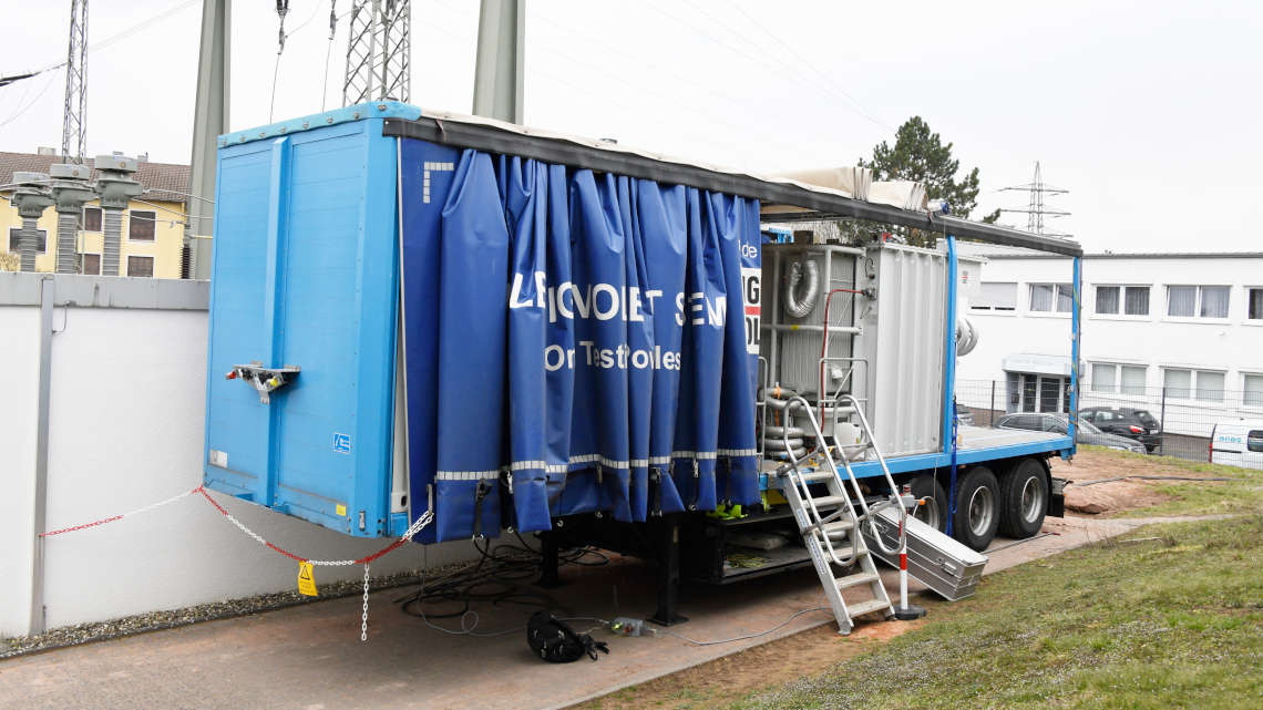 LKW-Anhänger wird entladen auf eingezäuntem Gelände für die 110 kV Prüfung