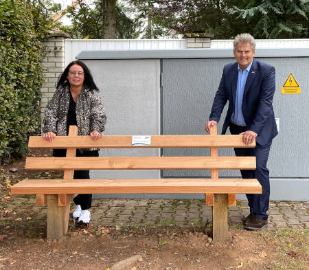 Personen hinter einer gespendeten Bank von der SWK in Erlenbach
