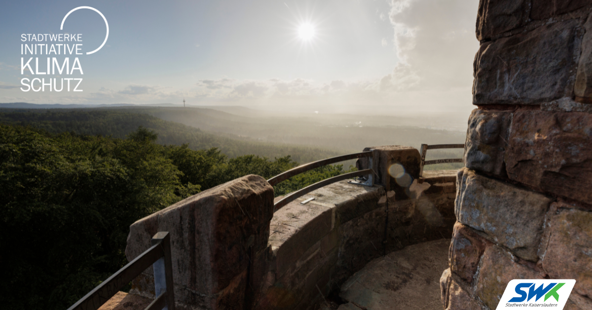 Ausblick von einer Burg ins Tal bei etwas Nebel, SWK-Logo und Stadtwerke Initiative Klimaschutz-Logo